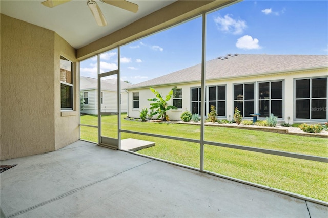 unfurnished sunroom featuring ceiling fan