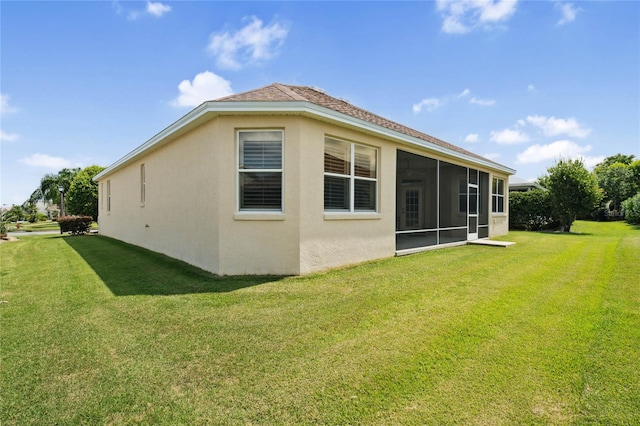 view of home's exterior with a lawn and a sunroom