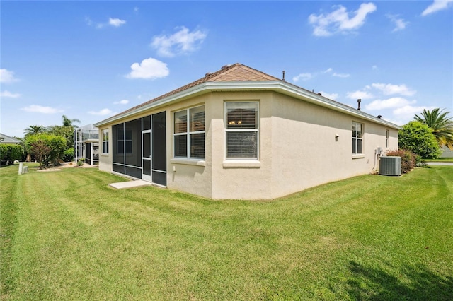 rear view of property with a sunroom, a lawn, and central air condition unit