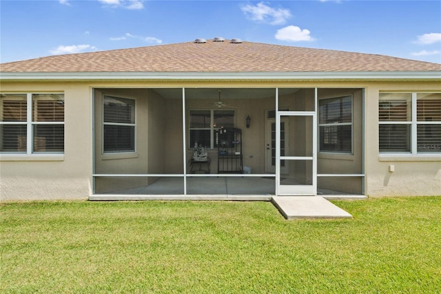 back of property with a lawn and a sunroom