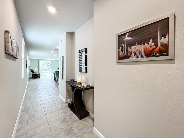 hallway featuring light tile patterned flooring, recessed lighting, and baseboards