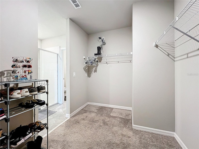 walk in closet with visible vents and light colored carpet