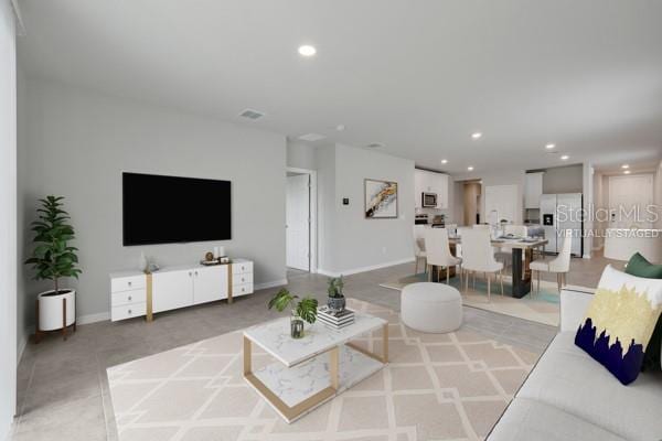 living area with visible vents, recessed lighting, and baseboards