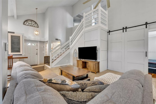 living room featuring a barn door, a high ceiling, and ceiling fan