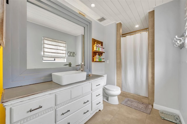 bathroom with vanity, toilet, walk in shower, and tile patterned flooring