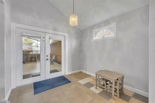 doorway with french doors, a chandelier, light tile patterned flooring, and vaulted ceiling