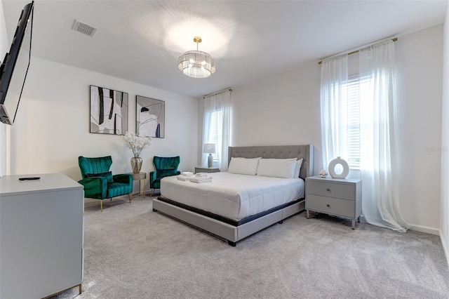 carpeted bedroom with a notable chandelier