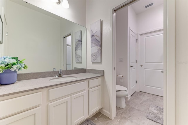 bathroom featuring vanity, toilet, and tile patterned flooring