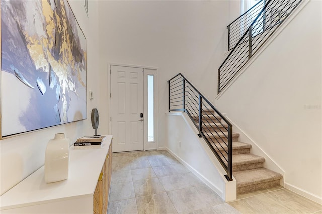 tiled foyer entrance with a towering ceiling