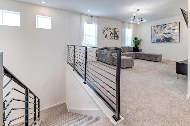 staircase featuring a chandelier and carpet