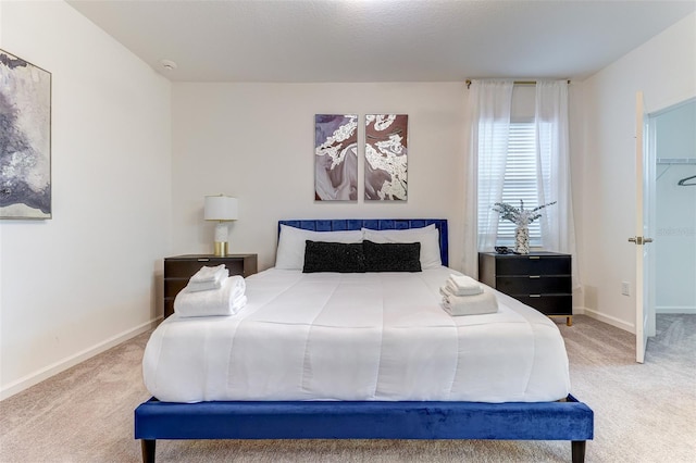 bedroom featuring a closet, a walk in closet, and carpet flooring