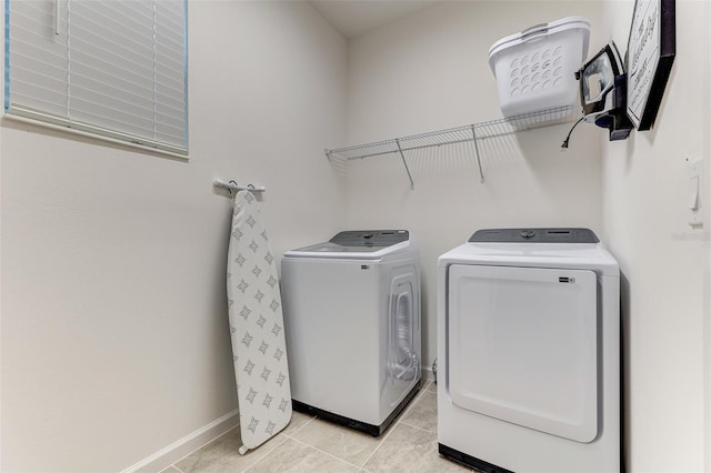 laundry room with washing machine and dryer and light tile patterned flooring