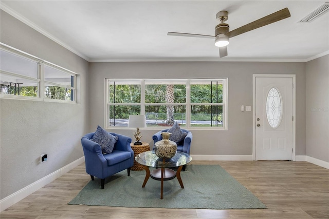 entrance foyer with a wealth of natural light, ceiling fan, ornamental molding, and light hardwood / wood-style floors