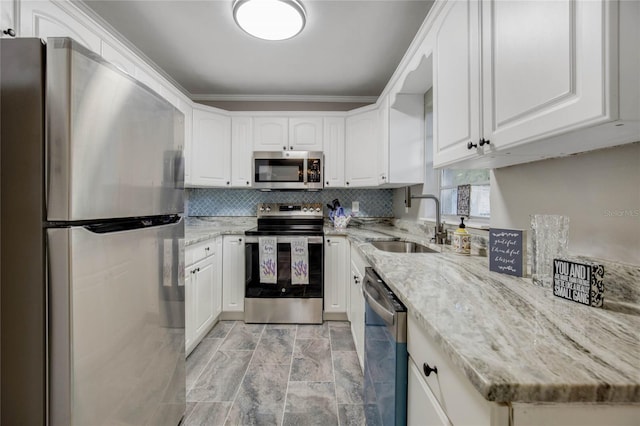 kitchen with light stone countertops, stainless steel appliances, white cabinetry, sink, and light tile patterned flooring