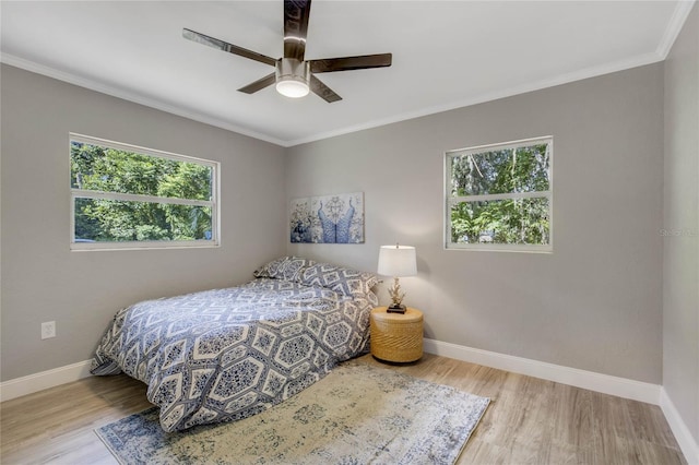 bedroom featuring ceiling fan, light hardwood / wood-style floors, and ornamental molding