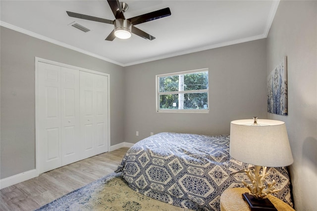 bedroom with crown molding, ceiling fan, a closet, and light hardwood / wood-style floors