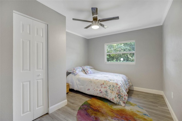 bedroom featuring a closet, ceiling fan, light hardwood / wood-style floors, and ornamental molding