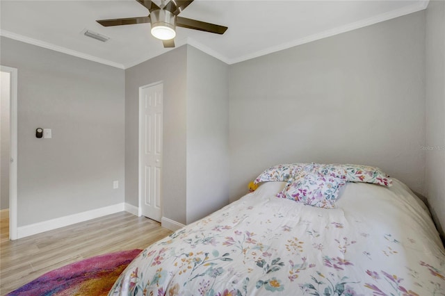 bedroom with light hardwood / wood-style flooring, ceiling fan, and ornamental molding