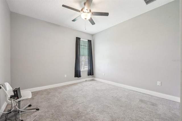 empty room with ceiling fan and light carpet