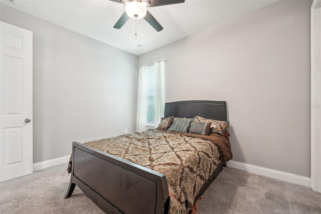 bedroom featuring a textured ceiling, ceiling fan, and light carpet