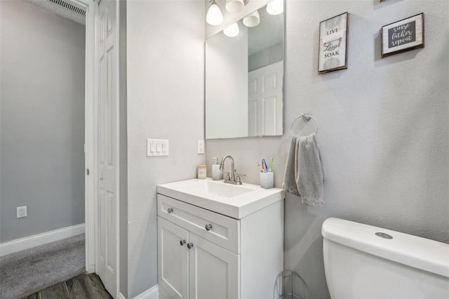 bathroom with vanity, toilet, and wood-type flooring