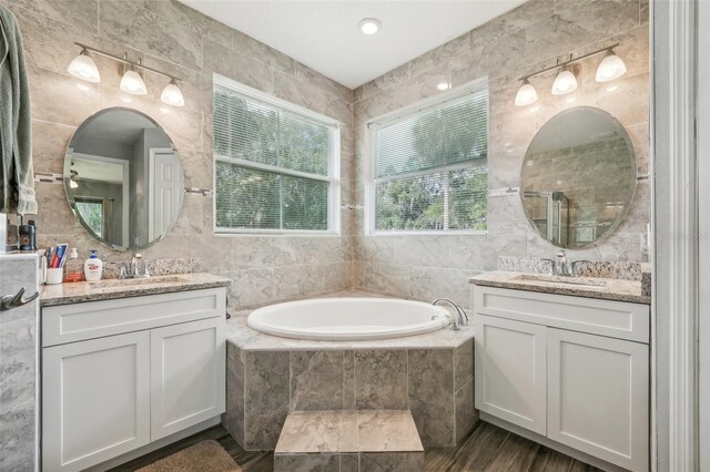 bathroom with tile walls, wood-type flooring, and vanity