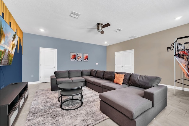 living room with ceiling fan and a textured ceiling