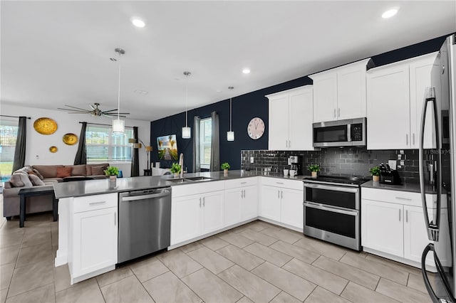 kitchen featuring decorative light fixtures, stainless steel appliances, white cabinetry, kitchen peninsula, and ceiling fan