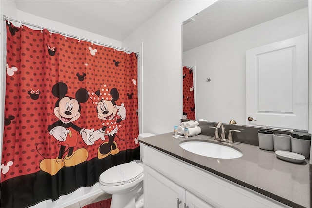 bathroom featuring vanity, toilet, walk in shower, and tile patterned flooring