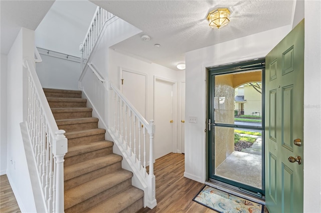 entryway featuring a textured ceiling and hardwood / wood-style flooring