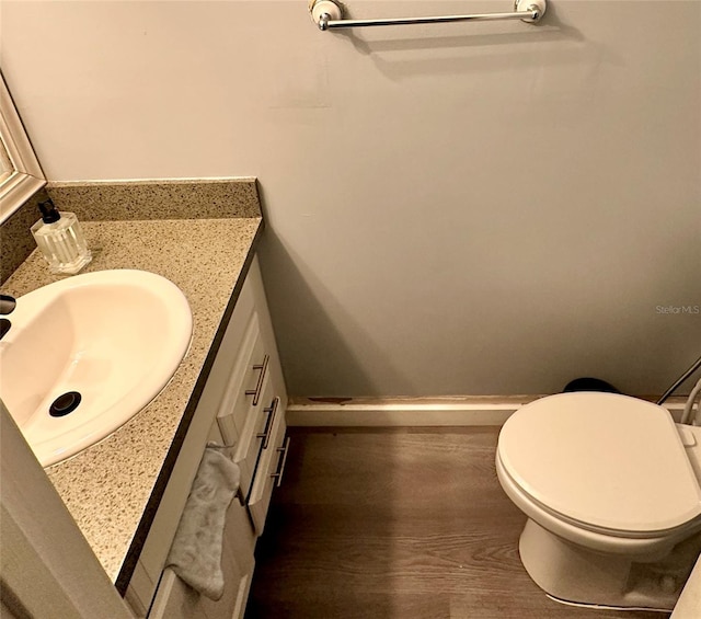 bathroom with vanity, toilet, and hardwood / wood-style floors