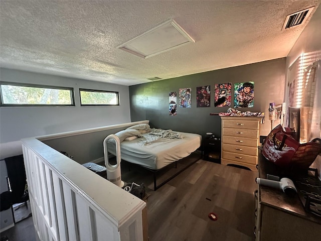 bedroom featuring a textured ceiling and dark hardwood / wood-style flooring