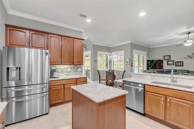 kitchen featuring appliances with stainless steel finishes, light stone countertops, sink, and ceiling fan