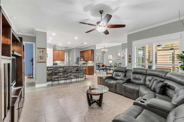 living room featuring ceiling fan with notable chandelier, light tile patterned floors, and crown molding