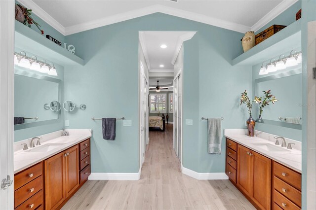 bathroom with vanity, vaulted ceiling, hardwood / wood-style floors, ornamental molding, and ceiling fan