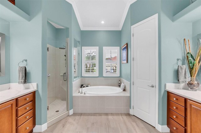 bathroom featuring vanity, ornamental molding, wood-type flooring, and plus walk in shower