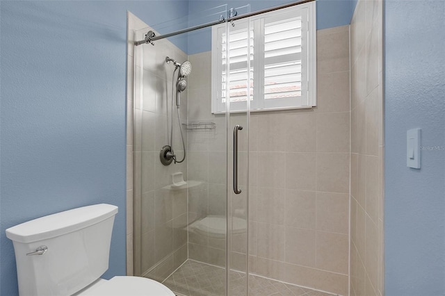 bathroom featuring toilet and an enclosed shower