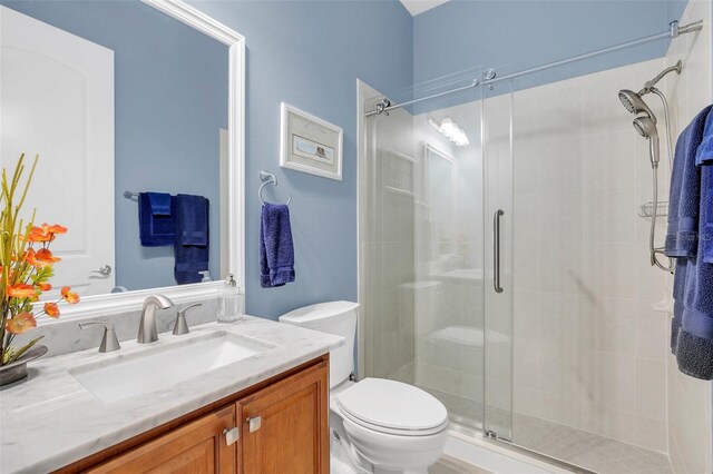 bathroom featuring vanity, toilet, and an enclosed shower