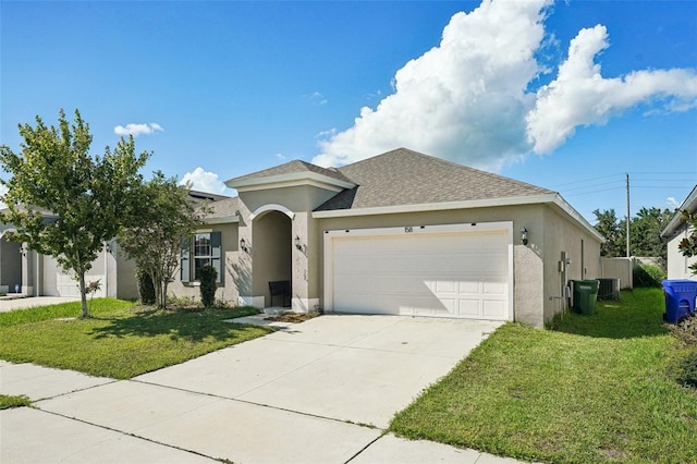 view of front of house with a garage, a front yard, and cooling unit