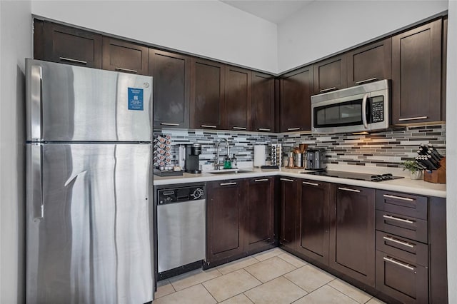 225 Celebration Pl Unit 427, Celebration, FL 34747 - kitchen with stainless steel appliances, light tile patterned floors, light countertops, dark brown cabinetry, and backsplash