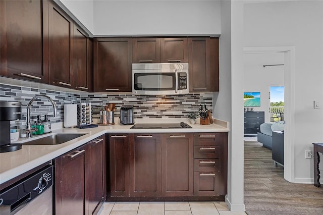 225 Celebration Pl Unit 427, Celebration, FL 34747 - kitchen featuring stainless steel appliances, light countertops, decorative backsplash, and dark brown cabinetry