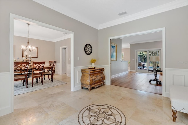 interior space featuring light hardwood / wood-style flooring, ornamental molding, and an inviting chandelier