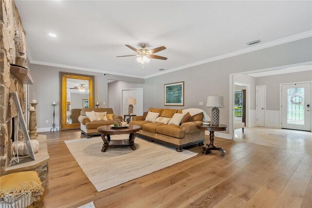 living room with a fireplace, light hardwood / wood-style floors, and ornamental molding