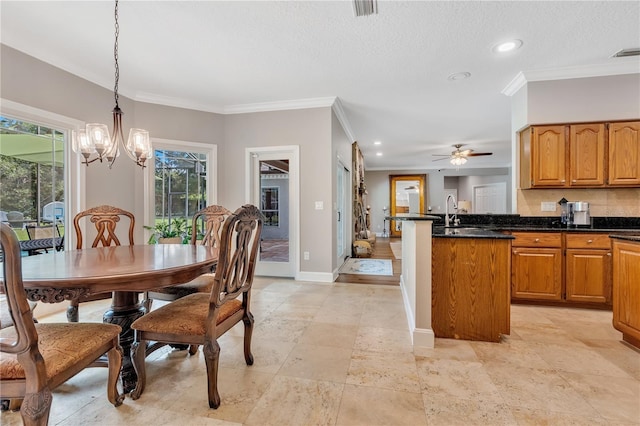 dining area featuring ceiling fan with notable chandelier, crown molding, and a textured ceiling