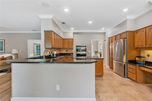 kitchen with kitchen peninsula, stainless steel appliances, crown molding, and dark stone counters