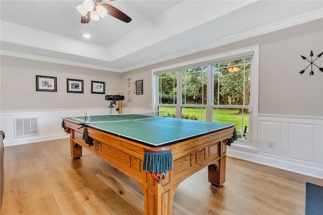 playroom featuring crown molding, ceiling fan, a tray ceiling, and light wood-type flooring