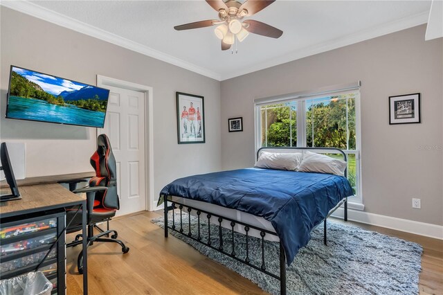 bedroom with light hardwood / wood-style flooring, ornamental molding, and ceiling fan