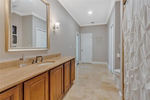 bathroom with crown molding, vanity, and toilet