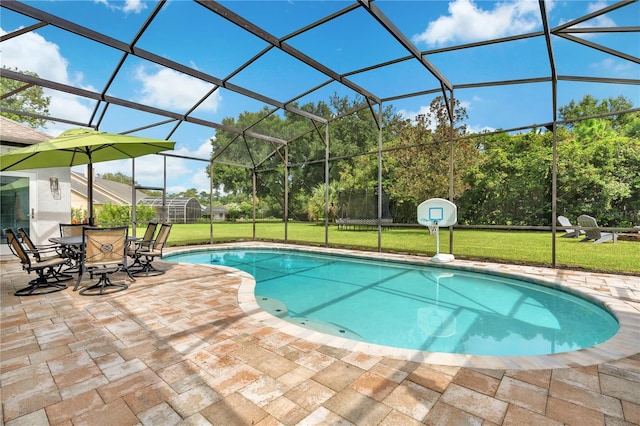 view of swimming pool featuring a patio, glass enclosure, and a lawn