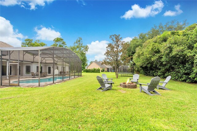 view of yard featuring glass enclosure and an outdoor fire pit